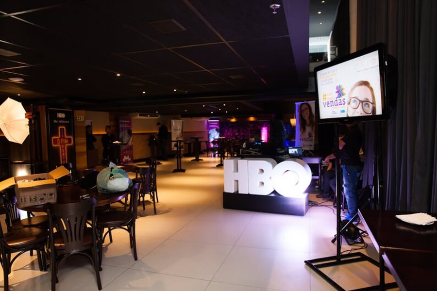 Ambiente de lançamento com letreiro luminoso da HBO, iluminação cênica e estrutura de transmissão