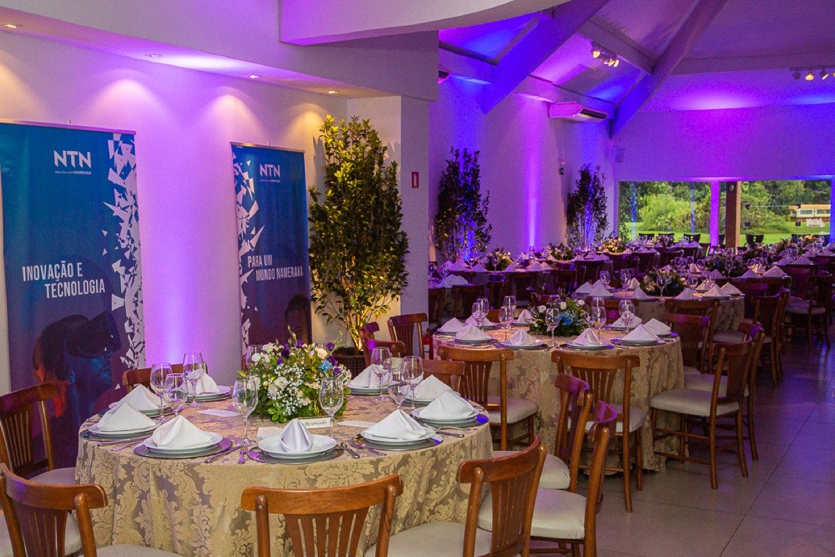 Jantar de gala corporativo com iluminação cênica roxa