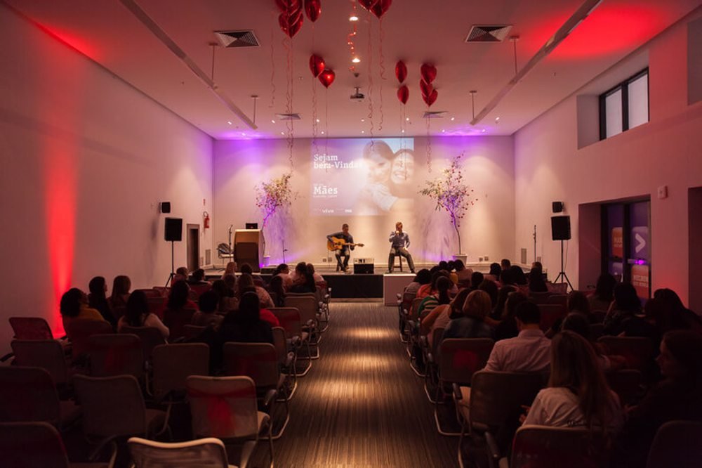 Palco de evento corporativo com iluminação e telão