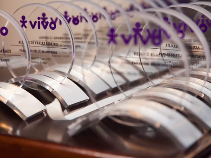 Troféus de premiação corporativa alinhados na mesa